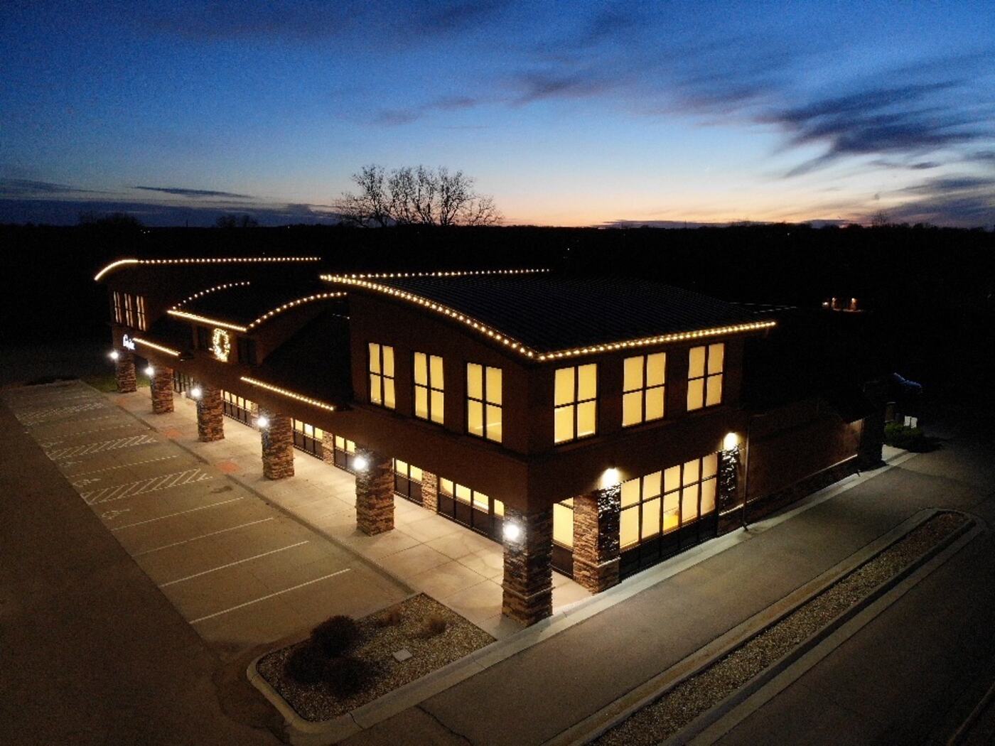Aerial view of a commercial building outlined in warm white light